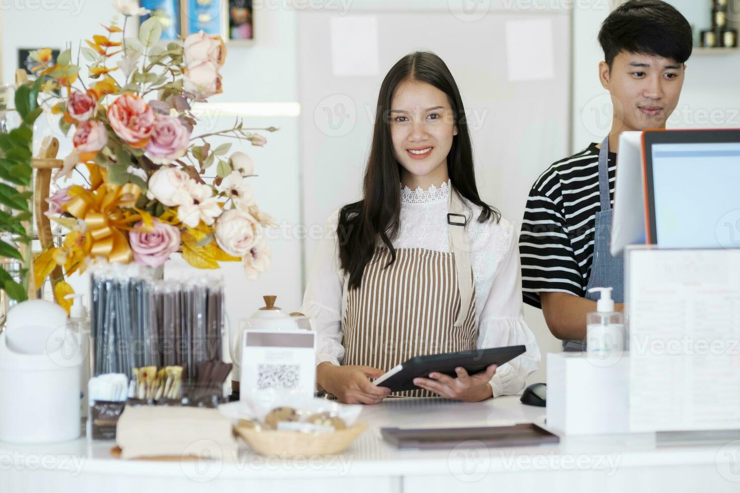 Happy Coffee Shop owner in an apron standing near a bar counter. photo