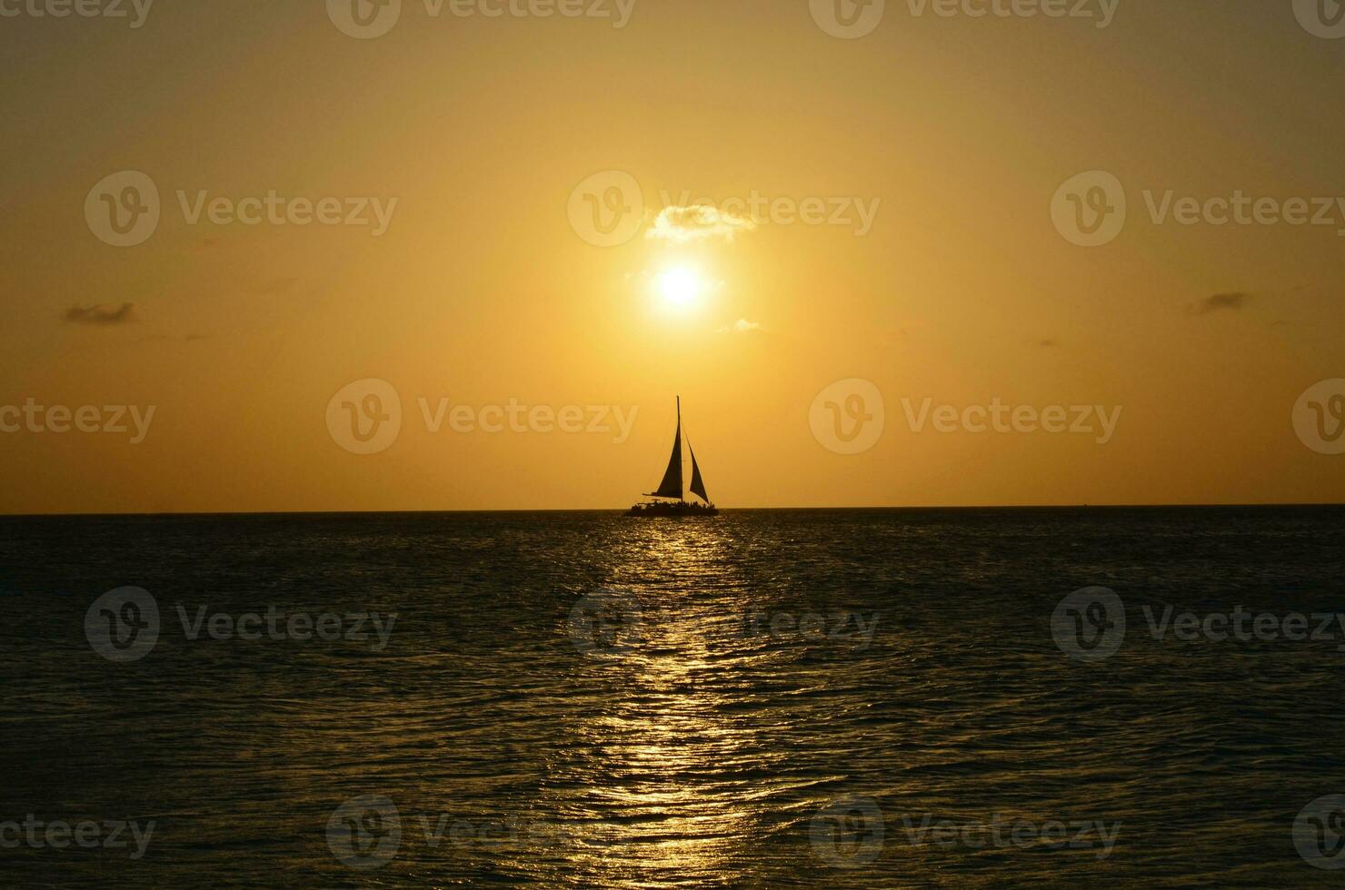 Sailboat Silhouetted on the Ocean Waters in Aruba photo