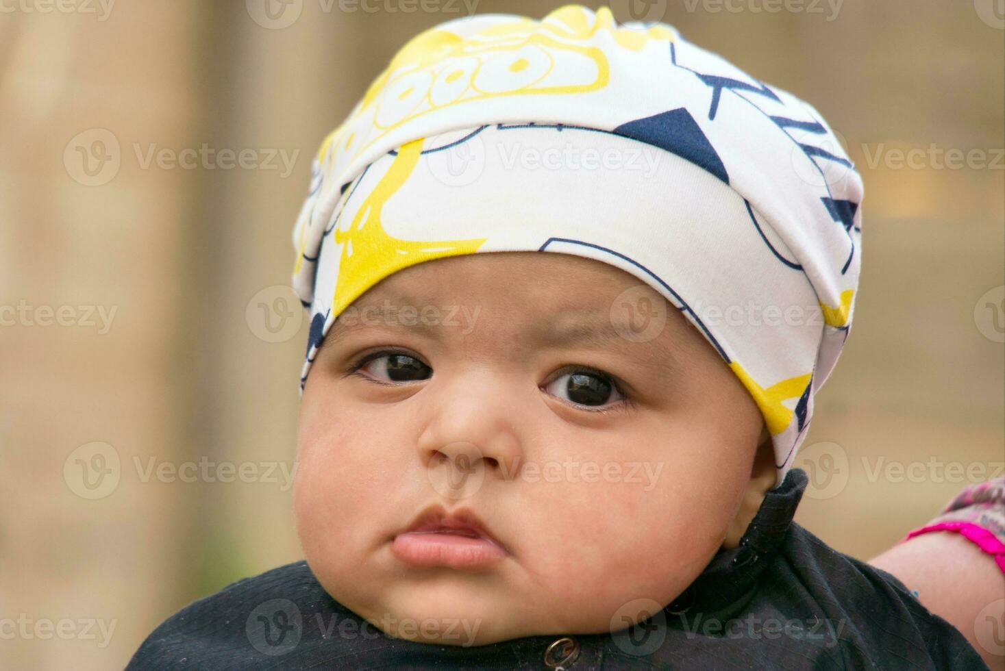 Close Up Shot of Cute Asian Pakistani 4 Months Old Baby Boy, Who is Enjoying at Home Garden at Luton City of England UK. Image Was Captured on July 23rd, 2023 photo