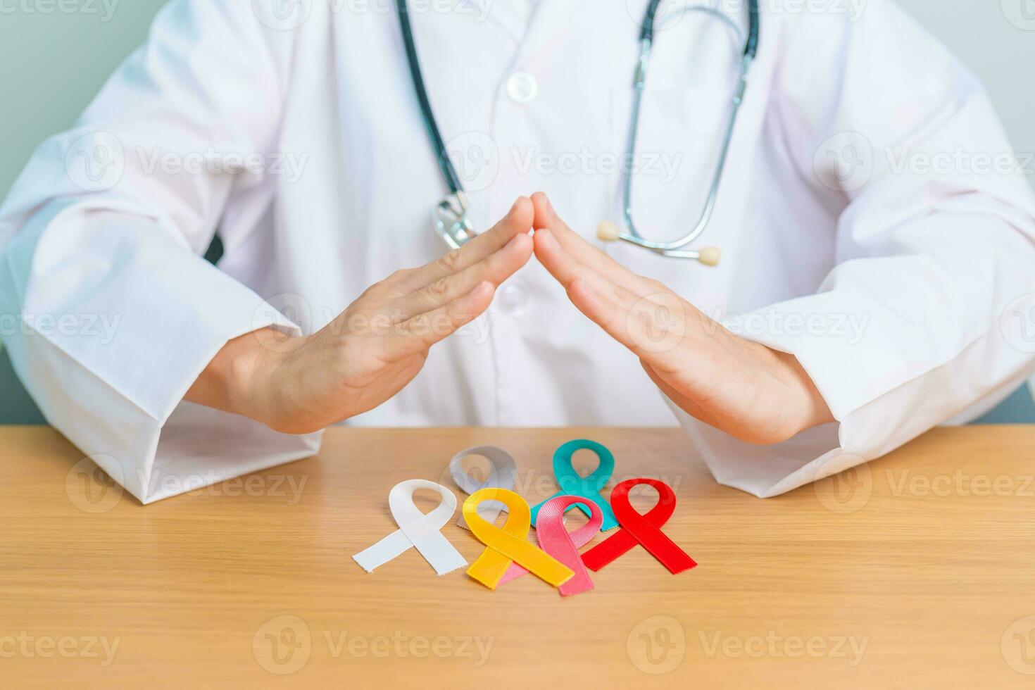 World cancer day, February 4. Doctor hand cover colorful ribbons, blue, yellow, red, white, pink and grey for supporting people living and illness. Health, Medical, awareness and Insurance concept photo