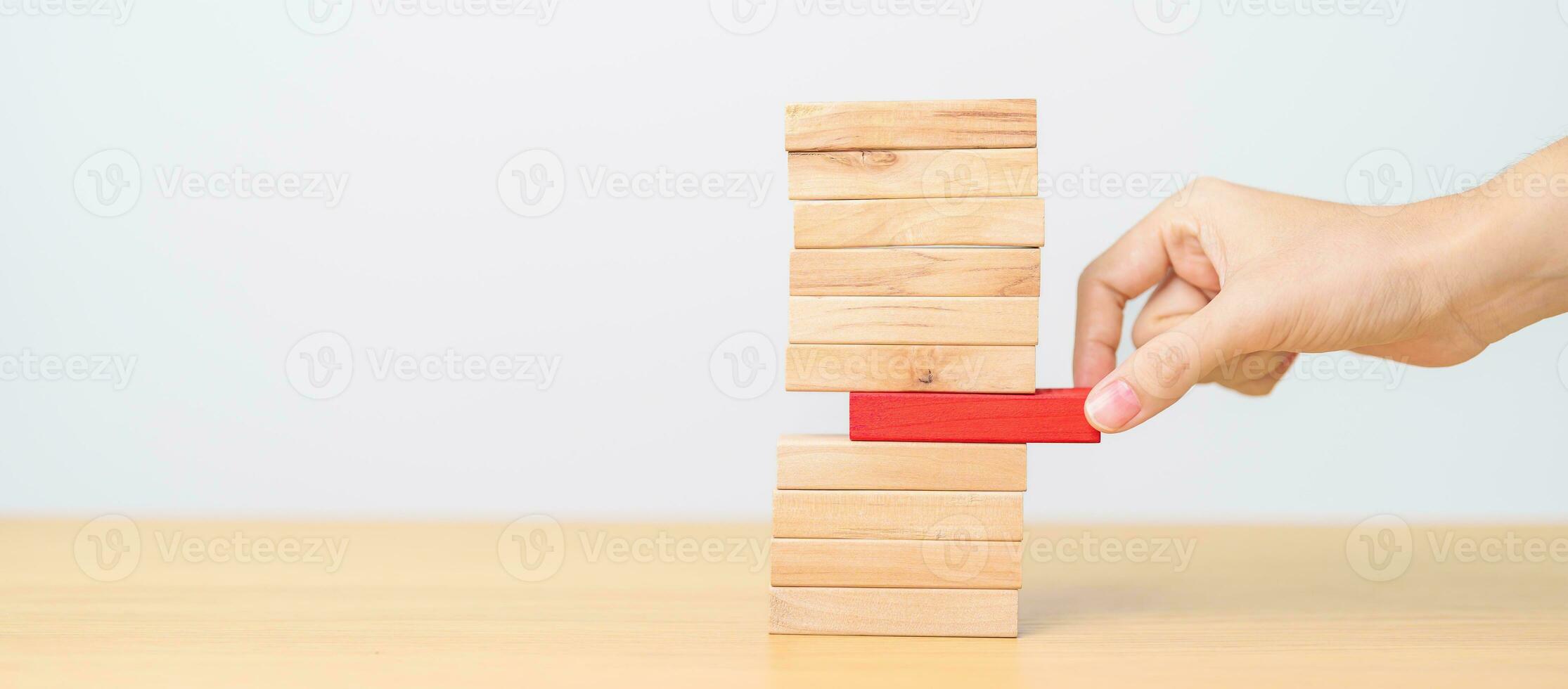woman hand pulling wood domino blocks on table. Crisis, fall Business, Risk management, Economic recession, Strategy and solutions concept photo