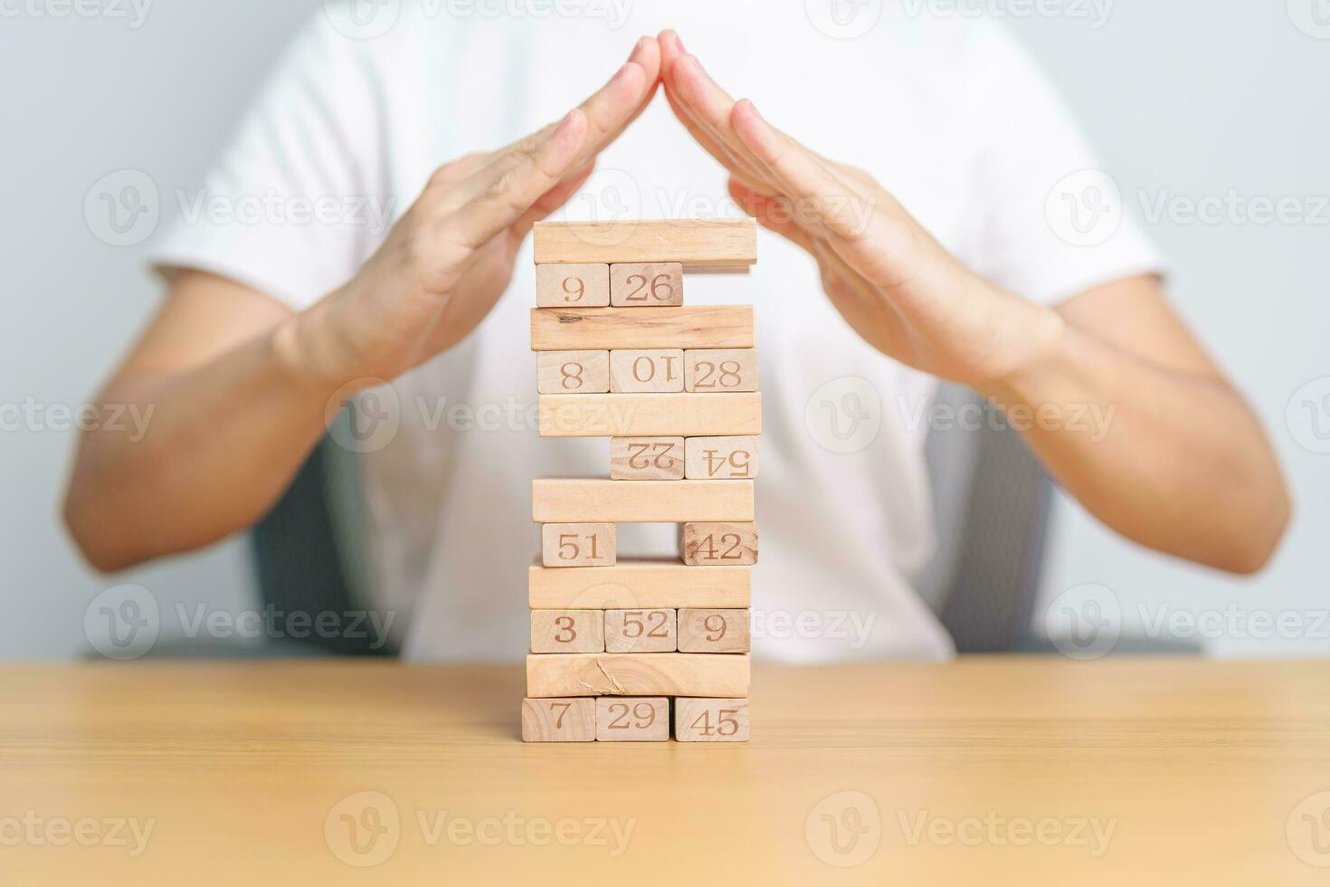 hand cover wooden block on the tower. Business planning, Risk Management, Solution, insurance and strategy Concepts photo
