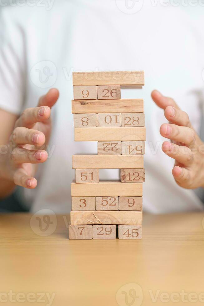 hand cover wooden block on the tower. Business planning, Risk Management, Solution, insurance and strategy Concepts photo