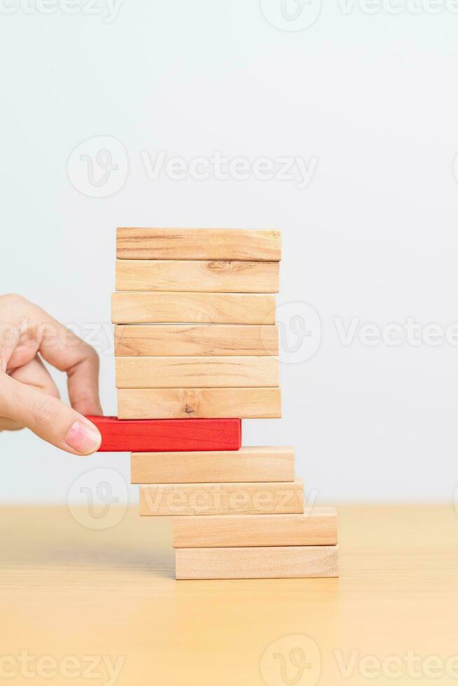 woman hand pulling wood domino blocks on table. Crisis, fall Business, Risk management, Economic recession, Strategy and solutions concept photo