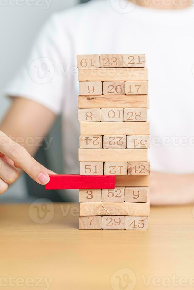 hand pulling wooden block tower on table. Business planning, Risk Management, Solution, leader, strategy, Crisis, falling Business, and Economic recession concept photo