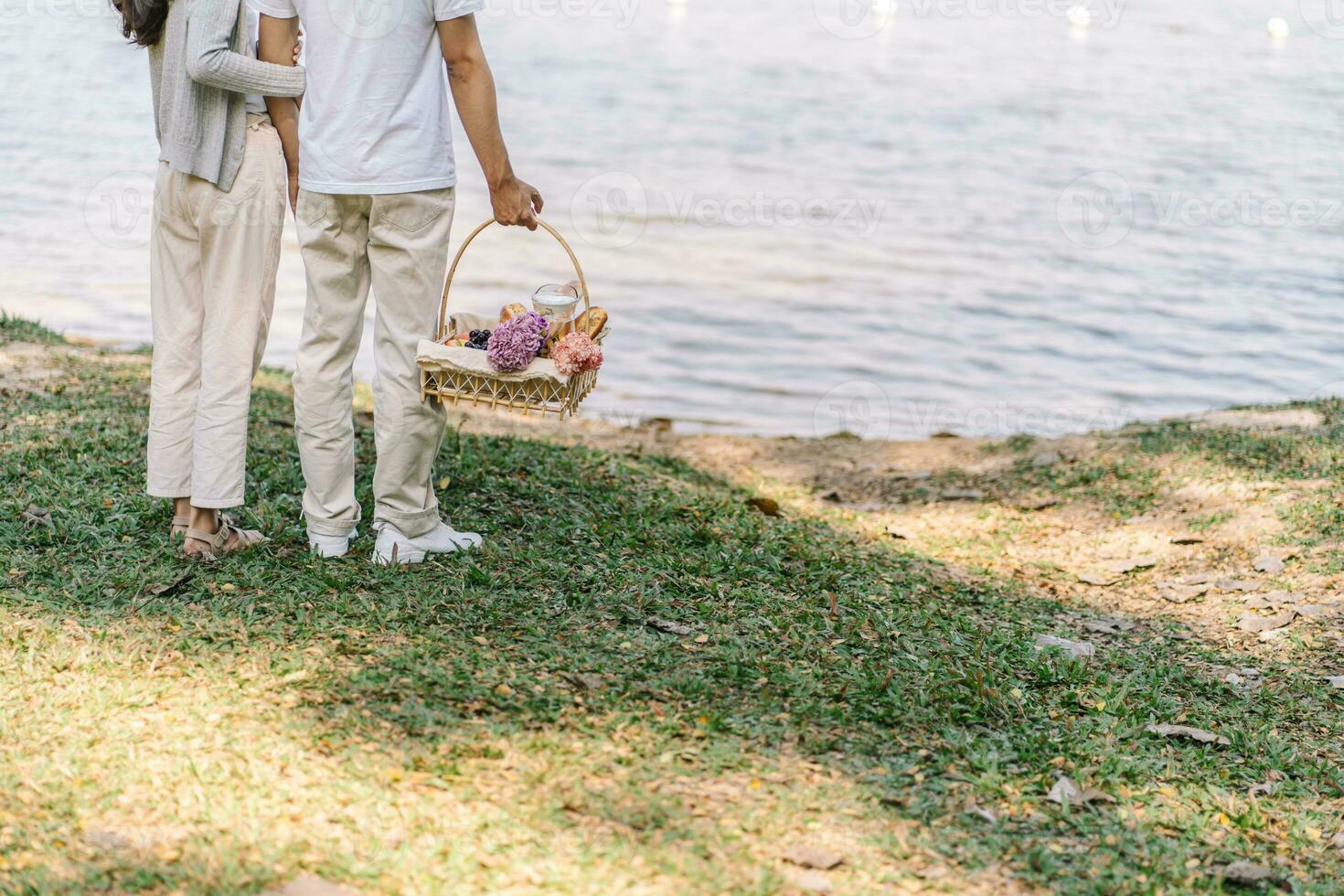 Couple walking in garden with picnic basket. in love couple is enjoying picnic time in park outdoors photo