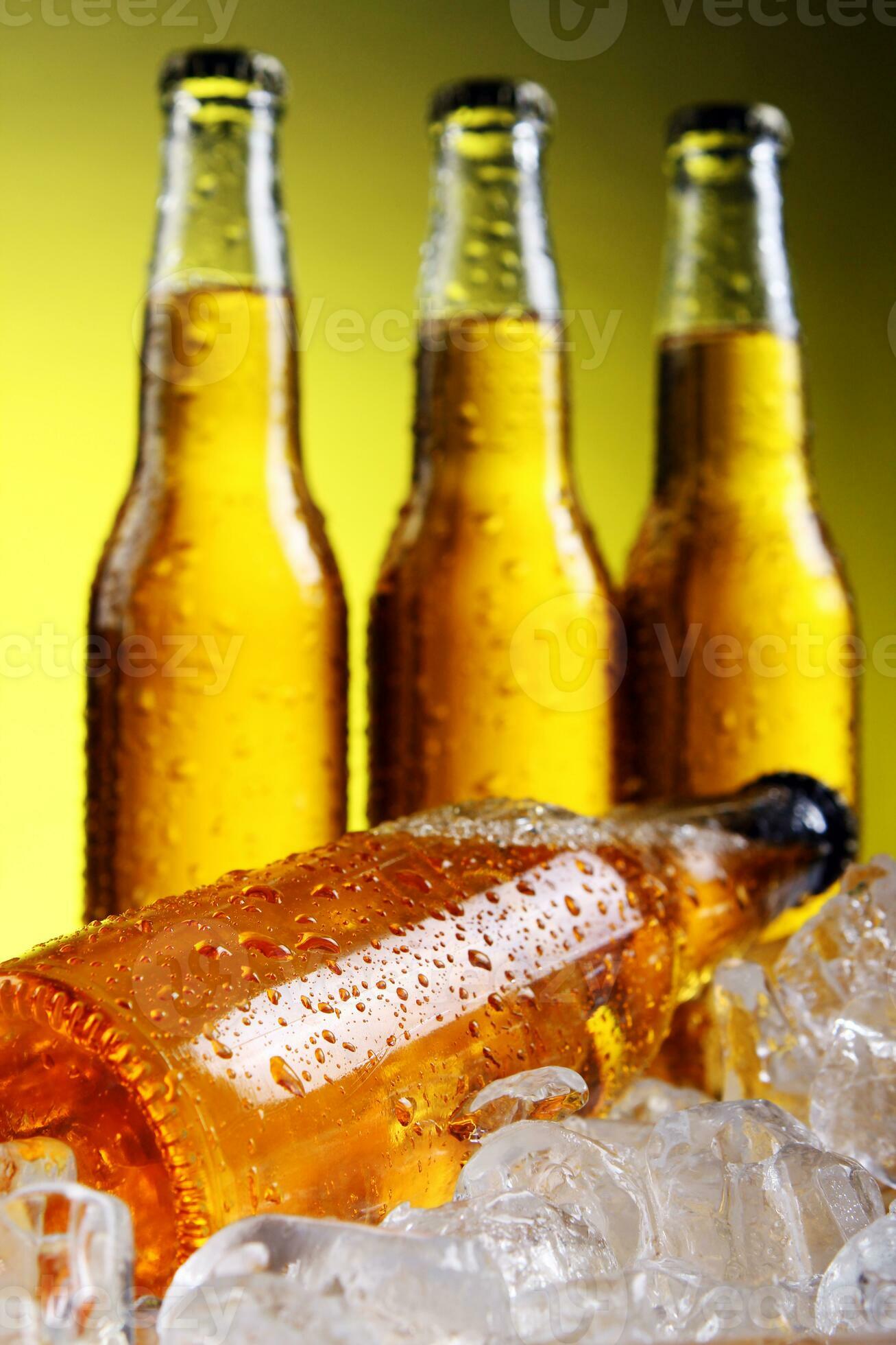 Free Stock Photo of Cold bottles of beer in ice on yellow background