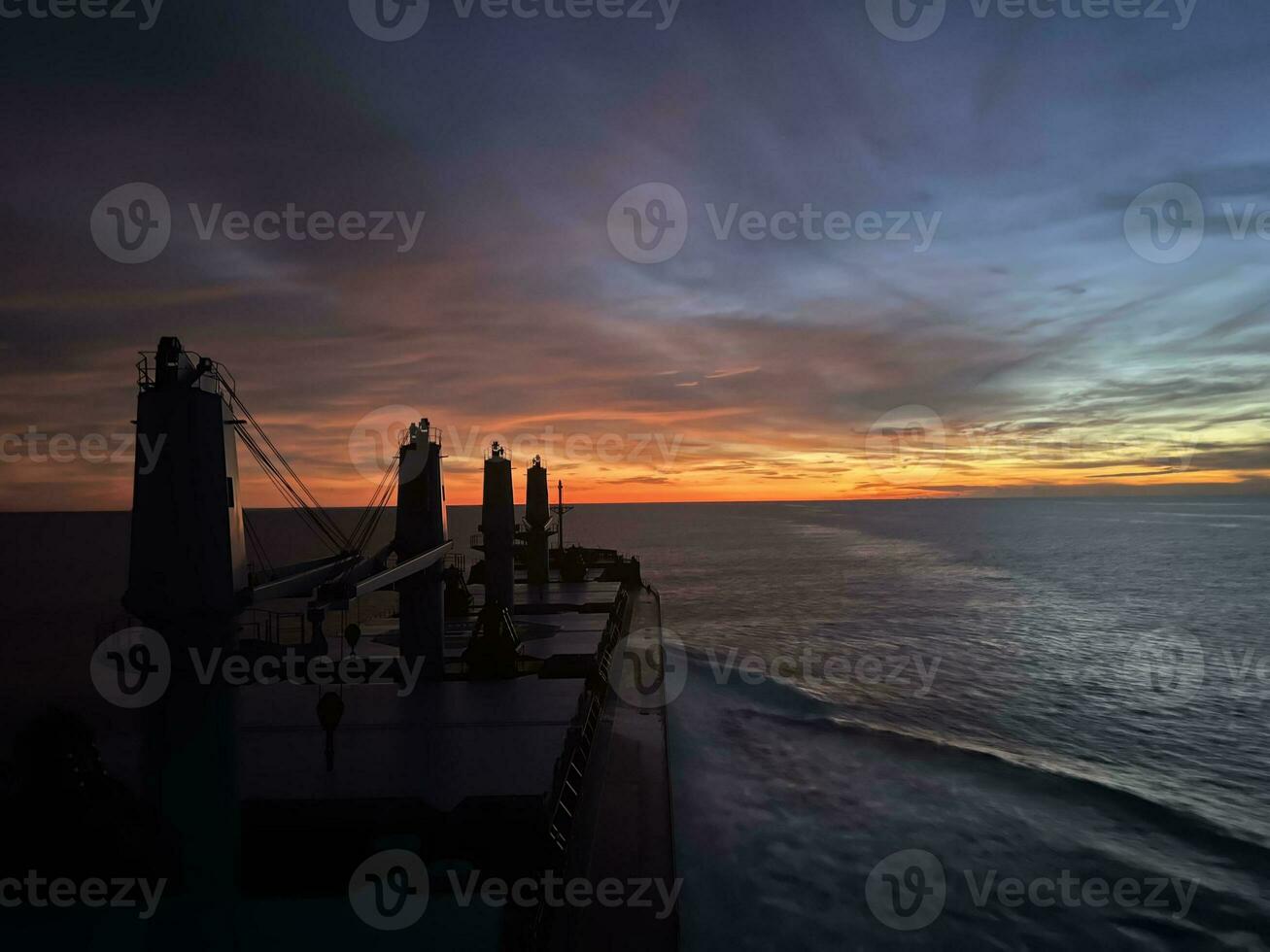 Sunset in the middle of the Indian Ocean. Ocean view from the bulk carrier bridge overlooking the hold photo