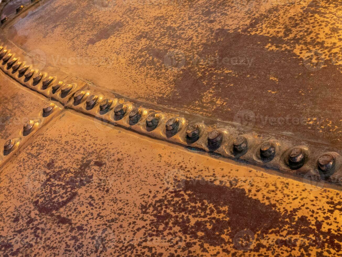 Metal background, old copper wall with rivets photo