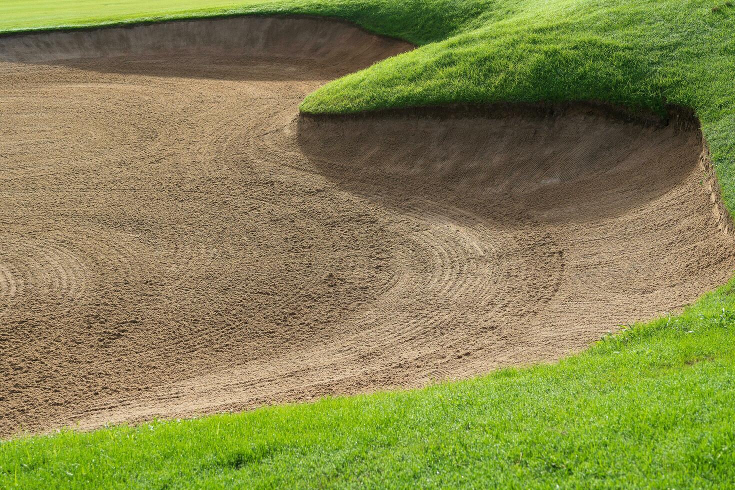 Golf Course Sand Pit Bunkers, green grass surrounding the beautiful sand holes is one of the most challenging obstacles for golfers and adds to the beauty of the golf course. photo