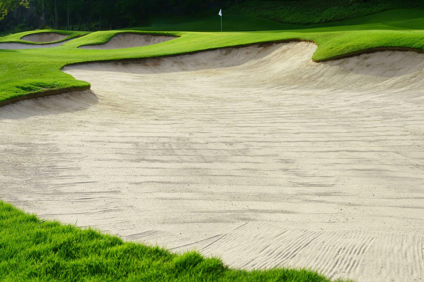 Golf Course Sand Pit Bunkers, green grass surrounding the beautiful sand holes is one of the most challenging obstacles for golfers and adds to the beauty of the golf course. photo