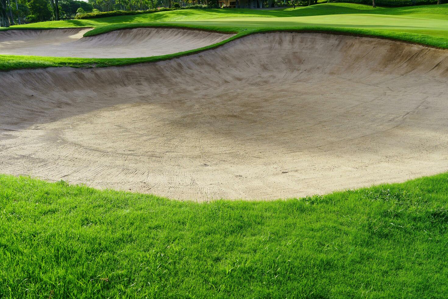 Golf Course Sand Pit Bunkers, green grass surrounding the beautiful sand holes is one of the most challenging obstacles for golfers and adds to the beauty of the golf course. photo