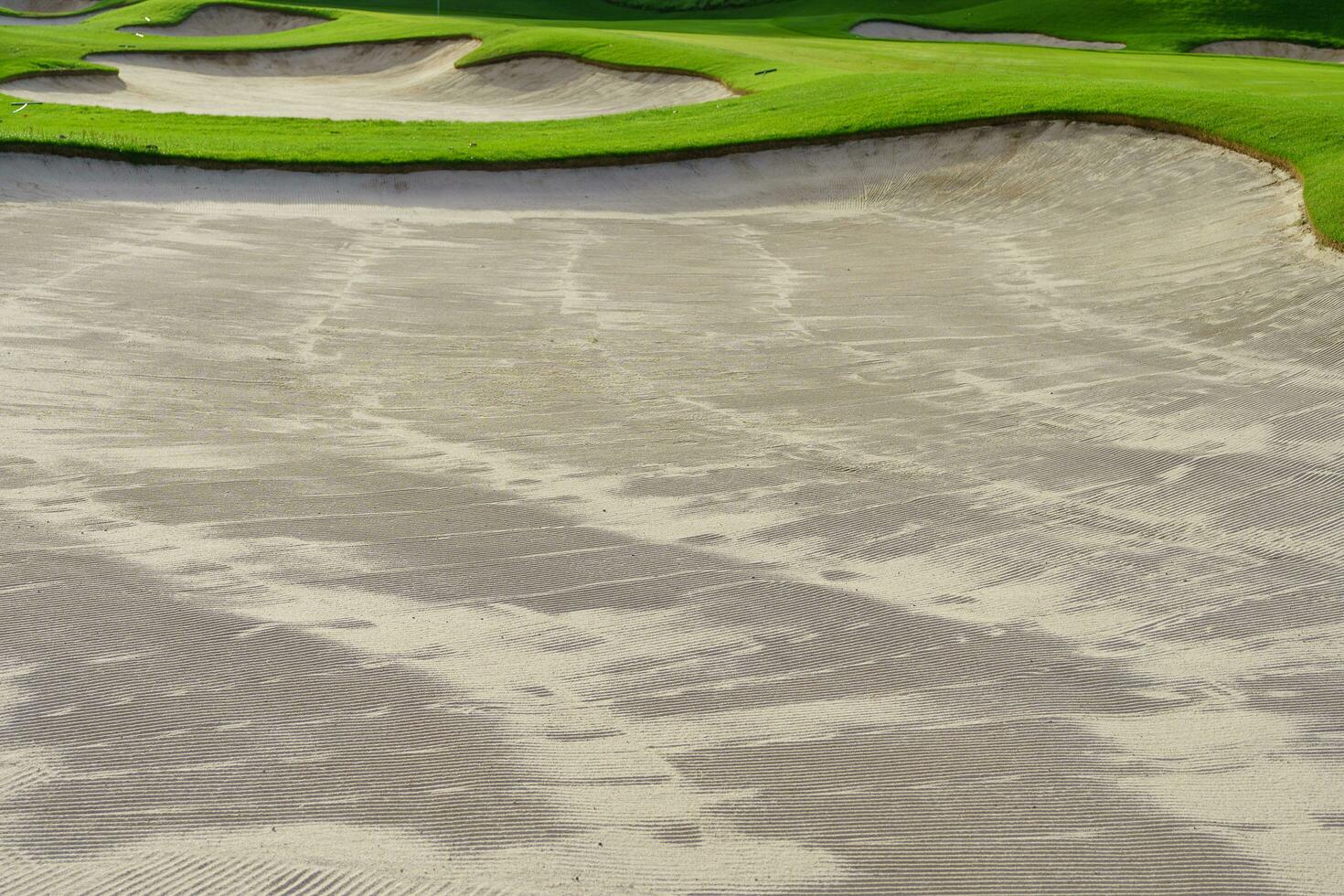 Golf Course Sand Pit Bunkers, green grass surrounding the beautiful sand holes is one of the most challenging obstacles for golfers and adds to the beauty of the golf course. photo