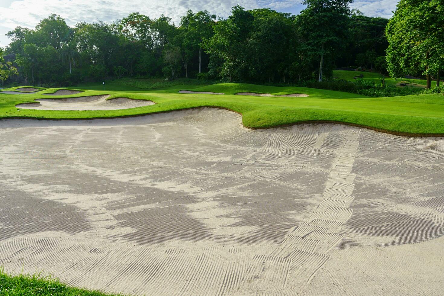 Golf Course Sand Pit Bunkers, green grass surrounding the beautiful sand holes is one of the most challenging obstacles for golfers and adds to the beauty of the golf course. photo