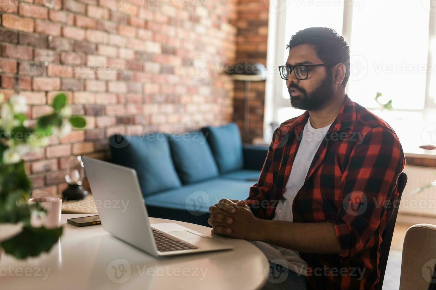 Happy indian man freelancer or entrepreneur have video conference talking, working remotely online at home office copy space - video call and diversity concept photo