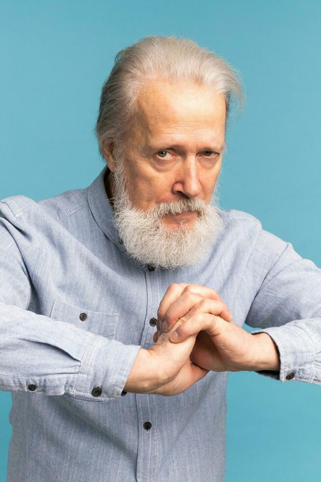 Portrait of angry pissed off bad senior mature man on blue background. Negative human emotions, face expression feelings photo