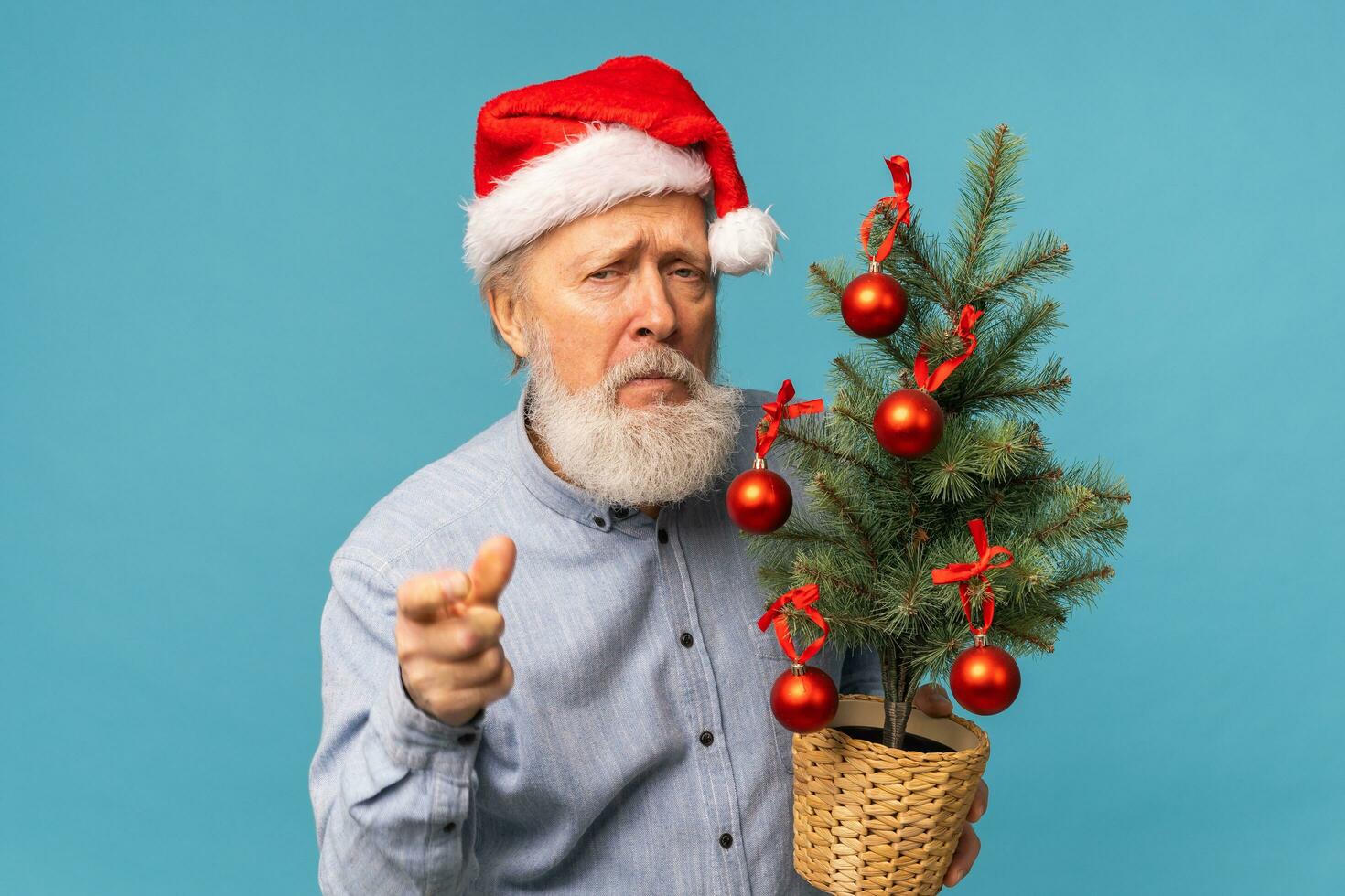 Gloomy Santa Claus portrait against blue background. Economy crisis and troubles end of year concept photo