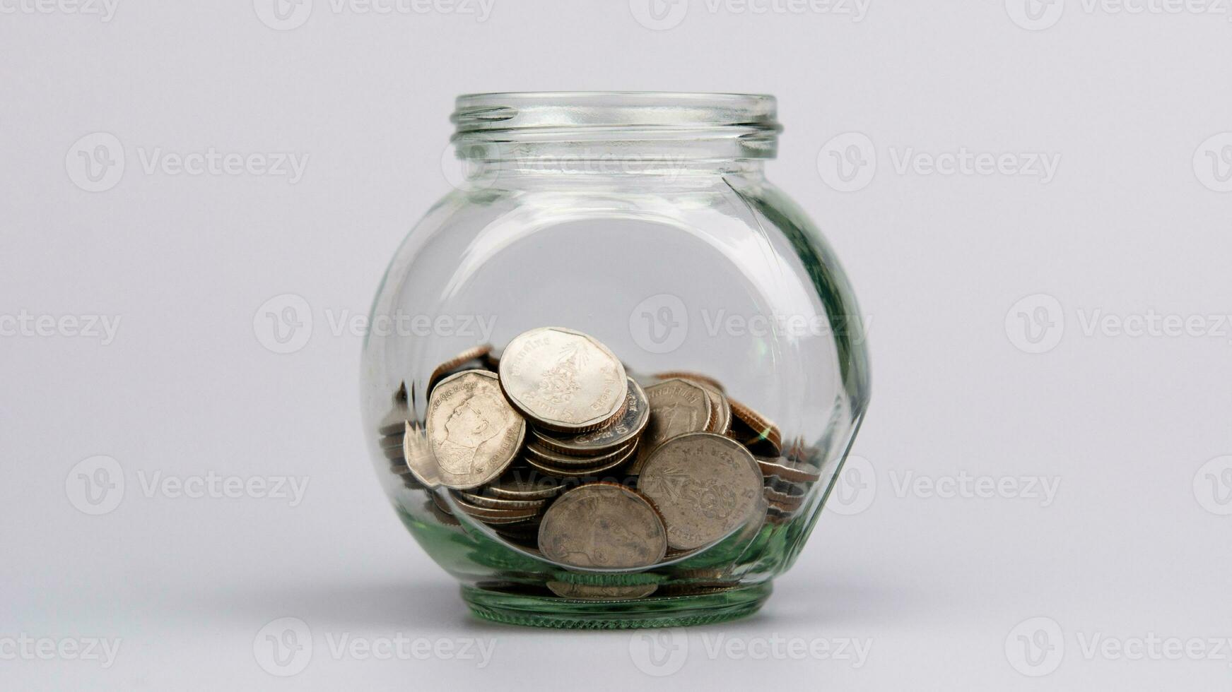 Saving coins in a glass jar collecting baht coins Salary, income, investments, setting up the financial system, funds, mutual funds, cash flow and working capital in the financial system. photo