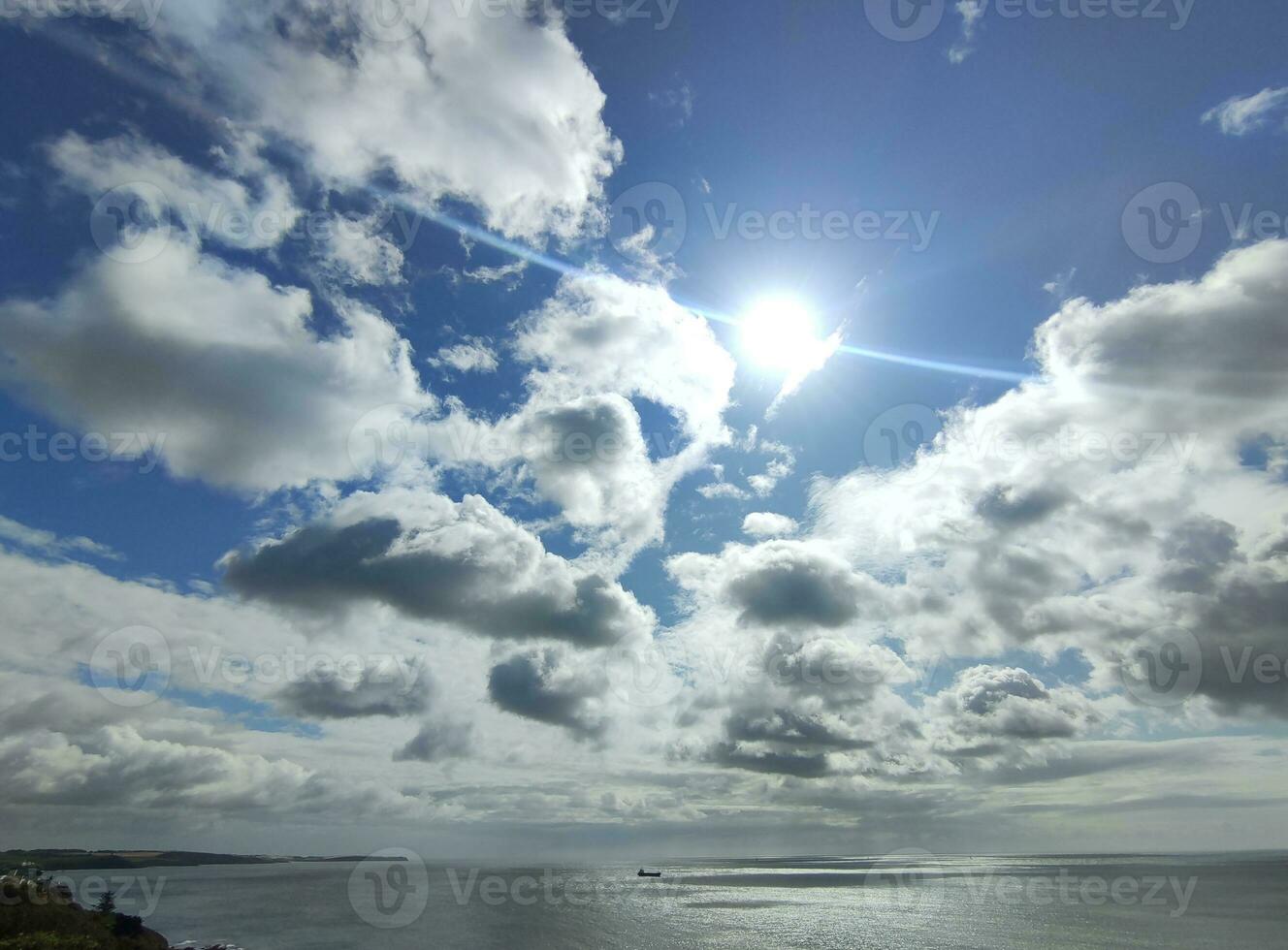 Cargo ship in the open sea. White clouds on a blue sunny sky background and sea photo