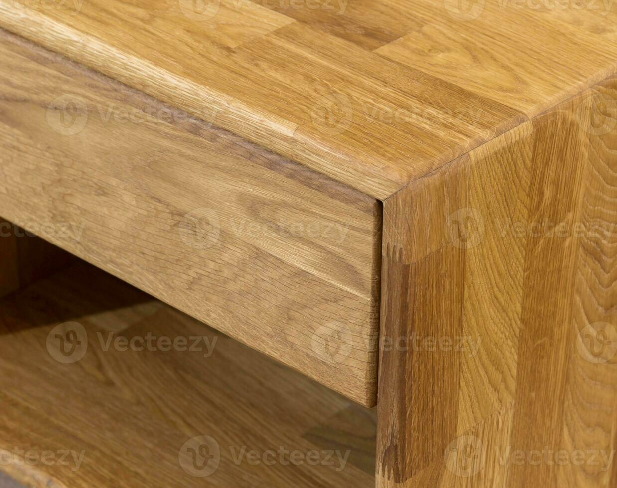 Wooden drawer of a nightstand close view photo, wooden eco furniture elements background. Solid wood furniture details photo