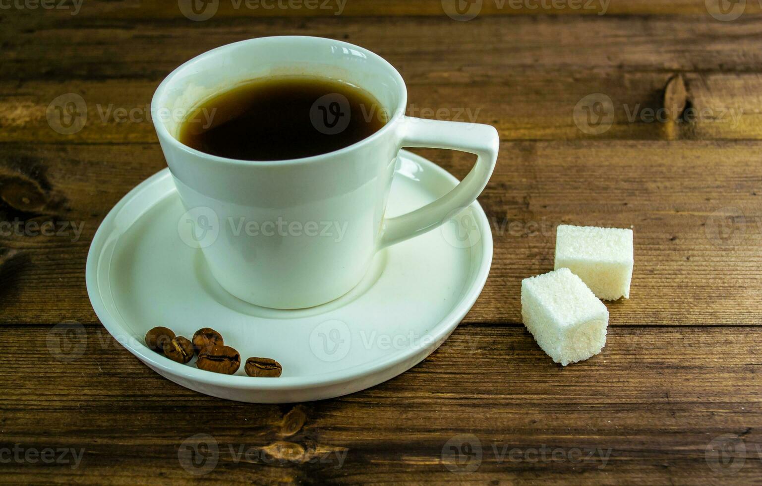 Coffee in a cup, coffee grains and sugar on the table. photo