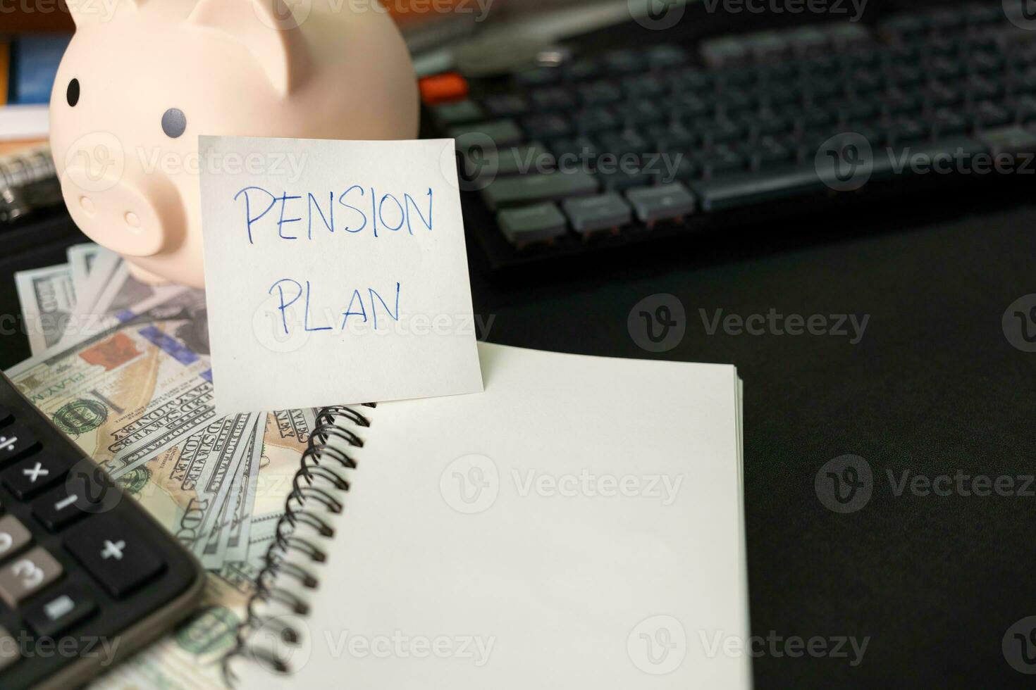 Paper note with text PENSION PLAN with stationery on desk. Pension Plan. Retirement concept. Pension calculation concept. copy space for text. Piggy bank. photo