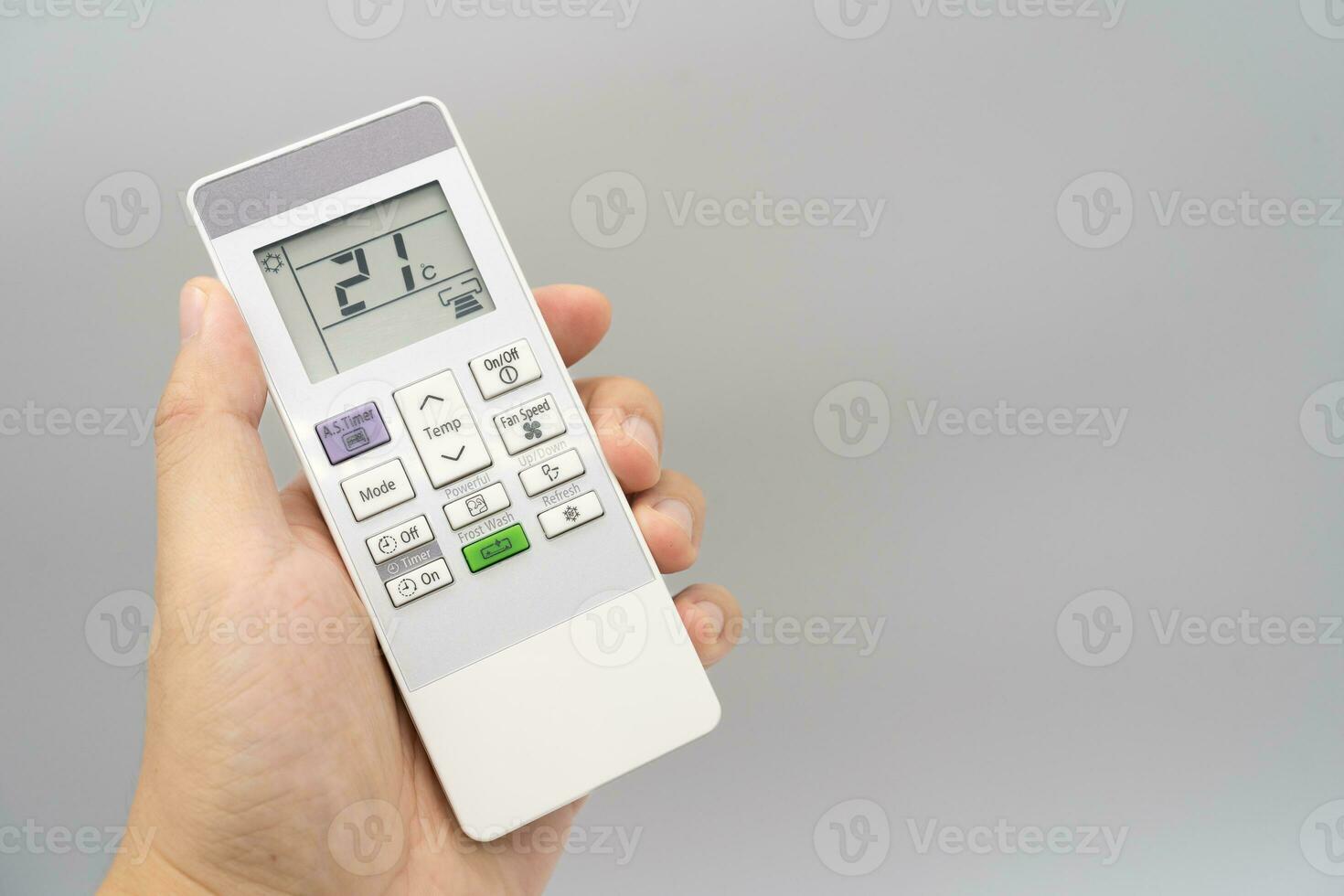 Hand holding air conditioner controller with buttons and display on isolated background. photo