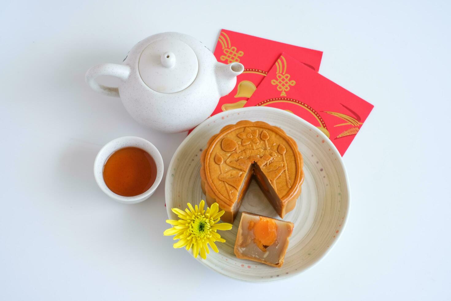 Top view of Chinese Mid-Autumn Festival concept made from mooncakes, tea decorated and red envelopes isolated on white background. photo