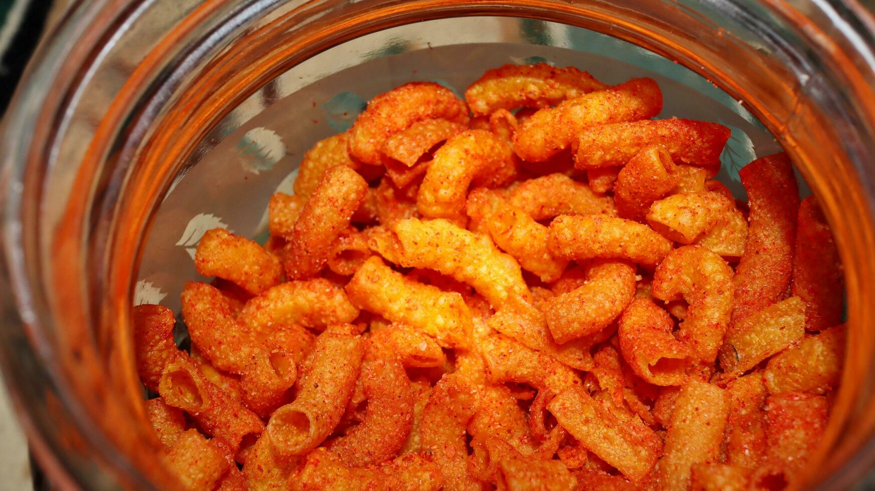 Red Spicy Fried Macaroni Texture in a glass container photo