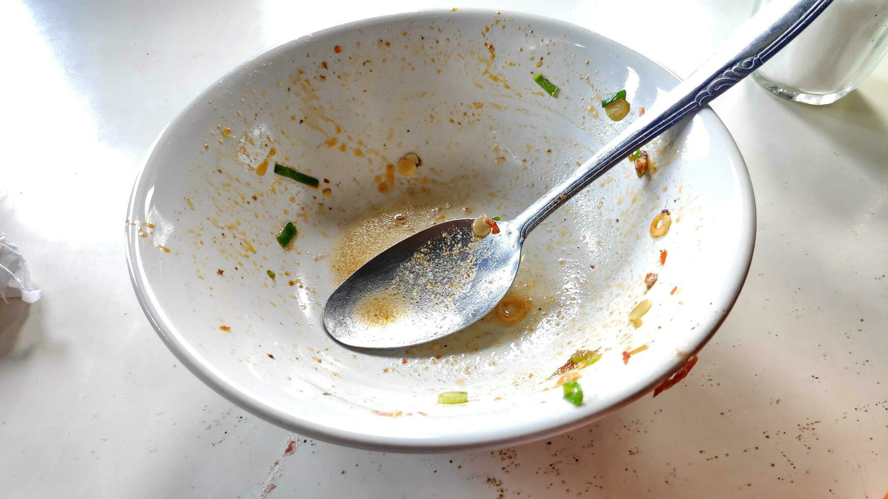 Empty bowl after eaten of spicy food put on white desk photo