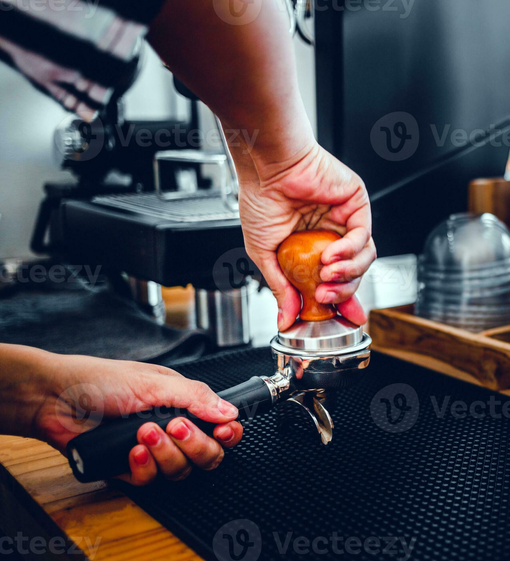 Close-up of hand Barista cafe making coffee with manual presses ground  coffee using a tamper at the coffee shop 27393656 Stock Photo at Vecteezy