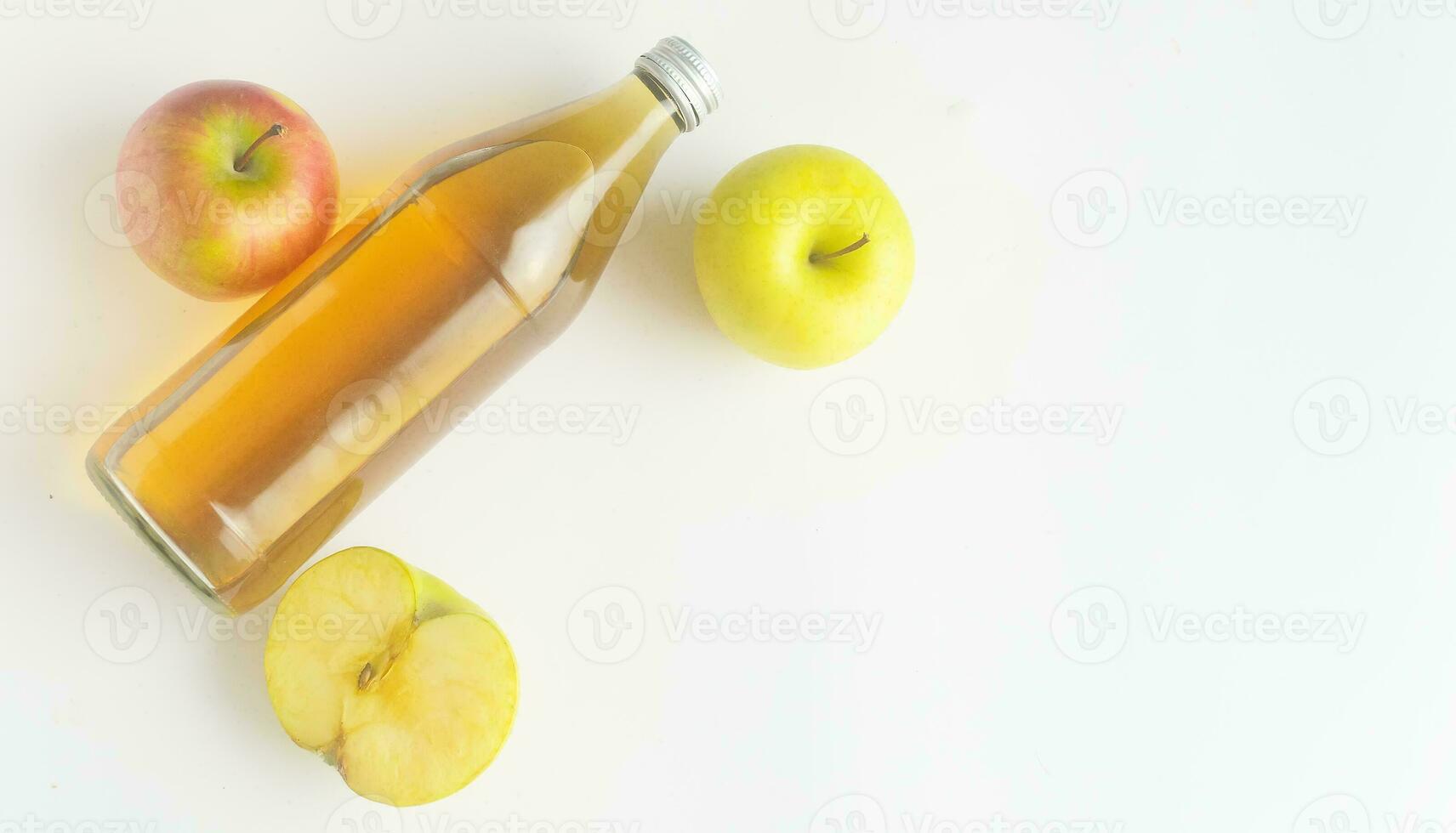 parte superior vista, un botella de manzana sidra vinagre y dos y medio manzanas en blanco fondo, espacio de copia. foto