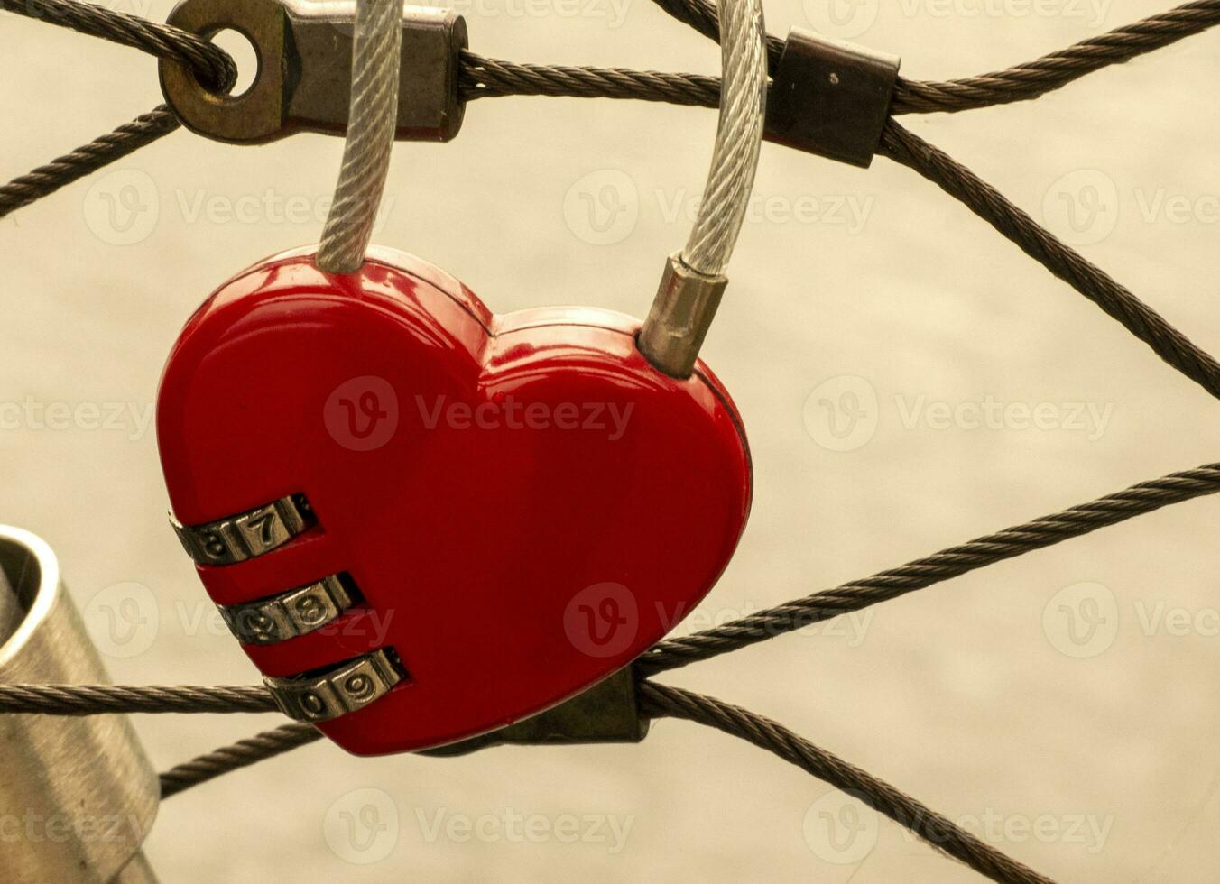 corazón bloquear a el puente, rojo corazón bloquear con un código, amor y pasión foto. un contraseña desde mi corazón concepto foto