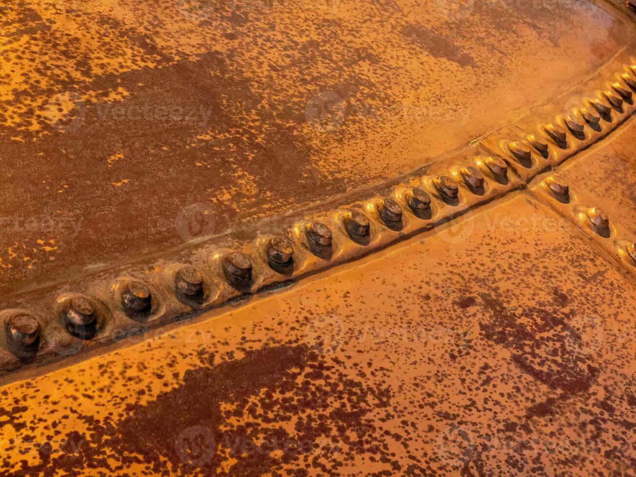 Metal background, old copper wall with rivets photo