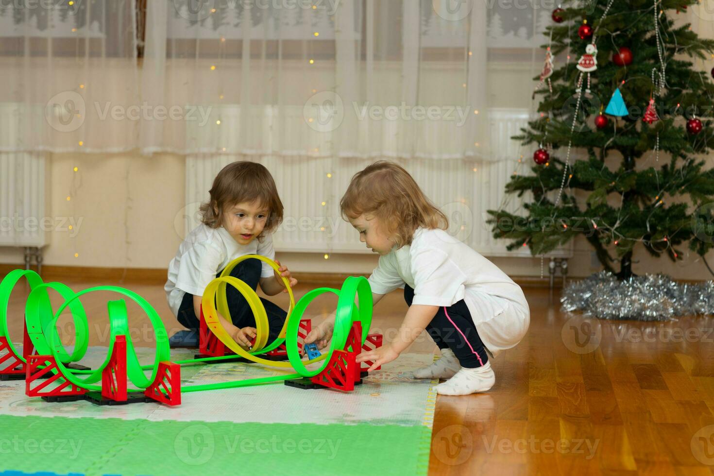 dos niños jugando con un juguete coche en un de madera piso foto