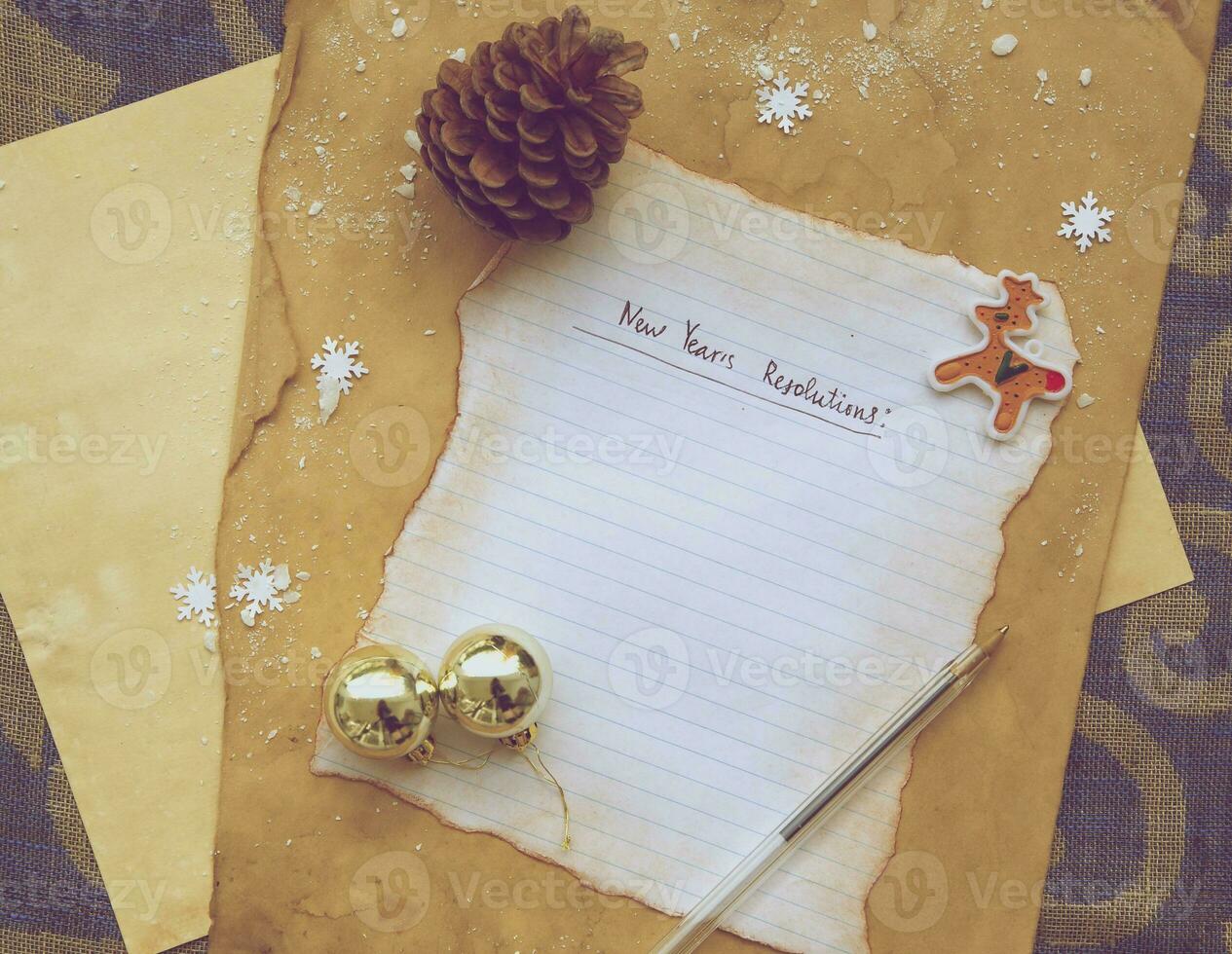 a paper with a christmas message and a pen on a brown background photo