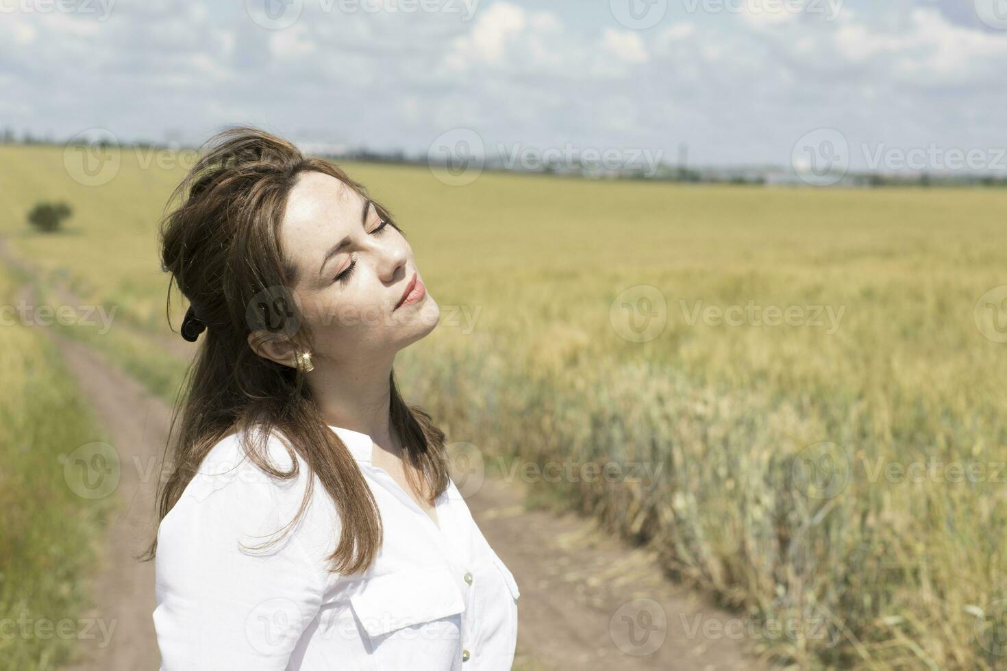 a woman in a white dress standing in a field photo