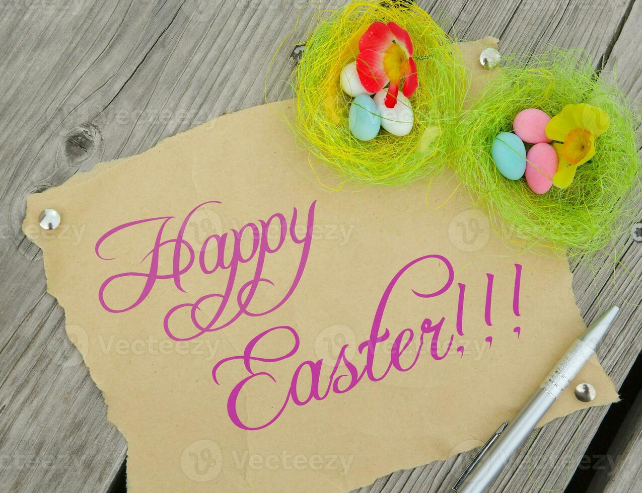 easter eggs and nest on wooden background with happy easter text photo