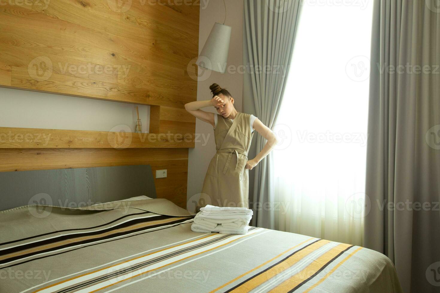 a woman standing in front of a bed photo