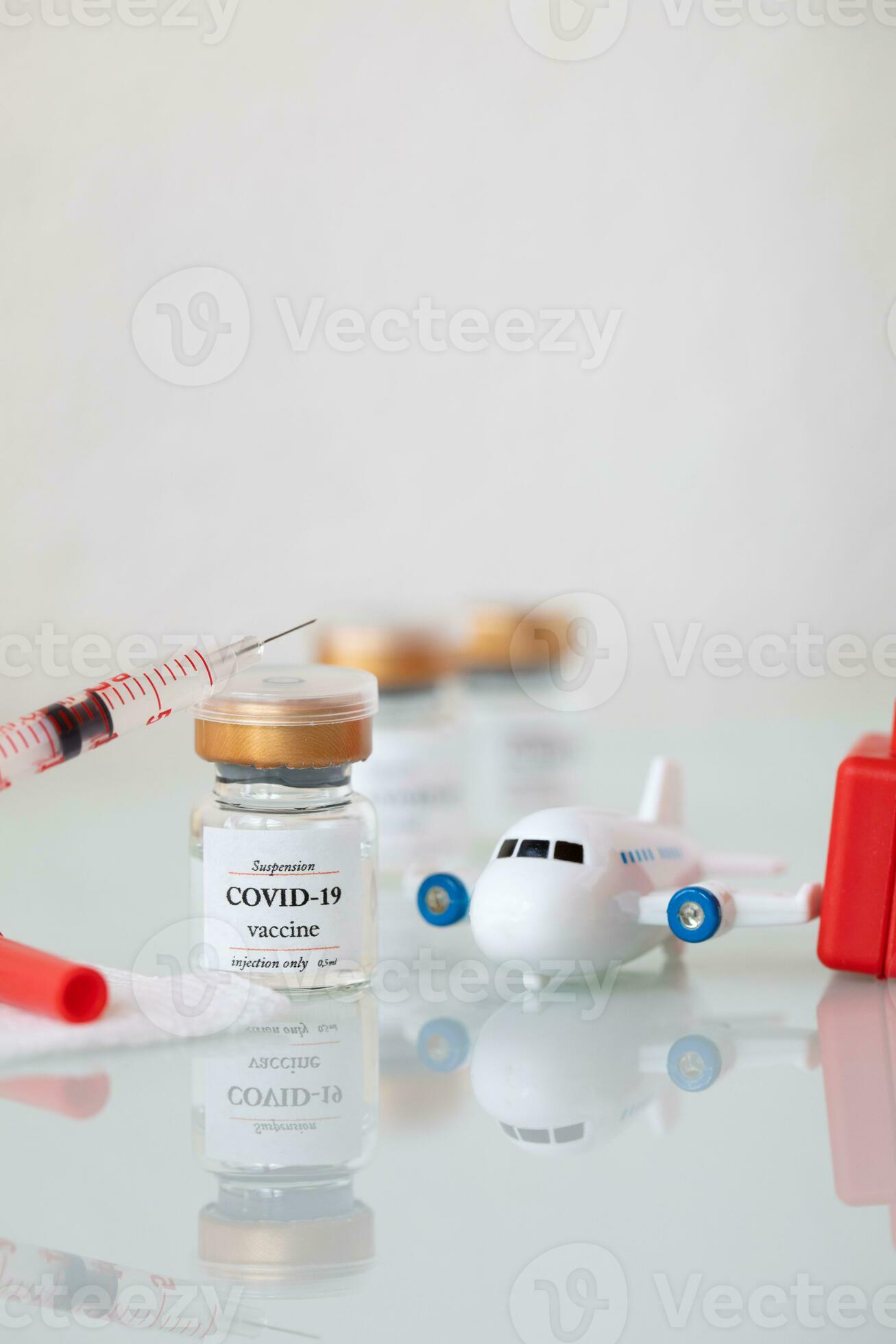 vaccine and syringe on a table with a toy airplane 27419976 Stock Photo