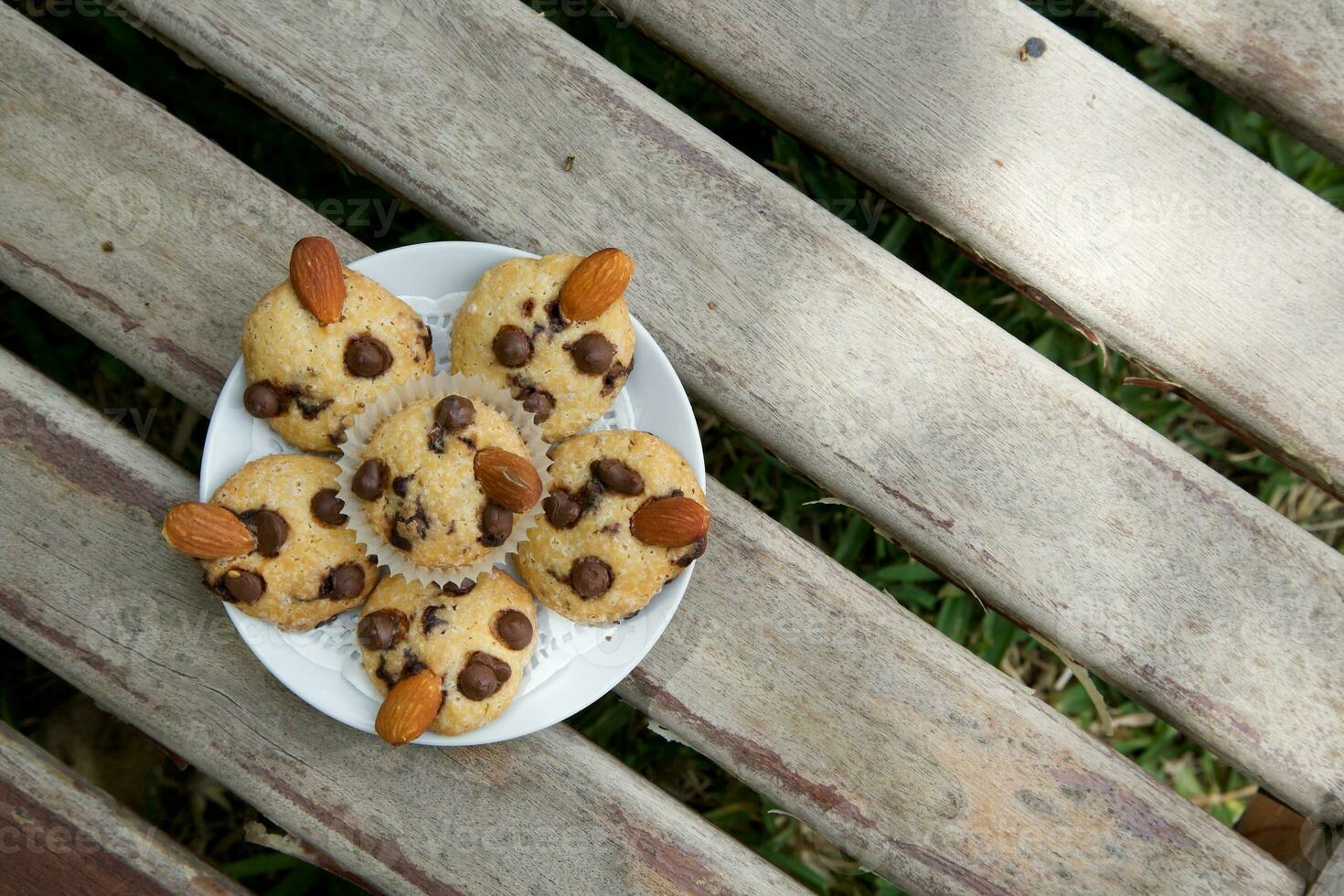 chocolate chip muffins on a plate on a wooden bench photo