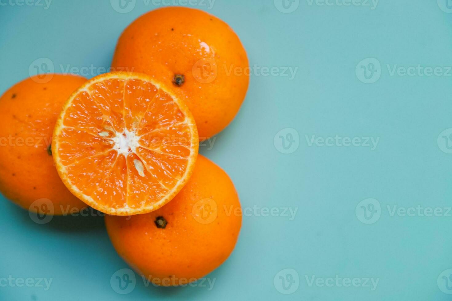 Flat lay of a few pieces of orange fruit on a blue table background photo