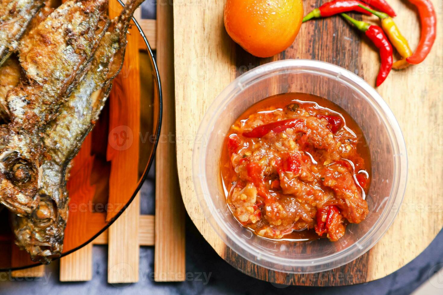 fried mackerel fish served on a plate with spicy sauce photo