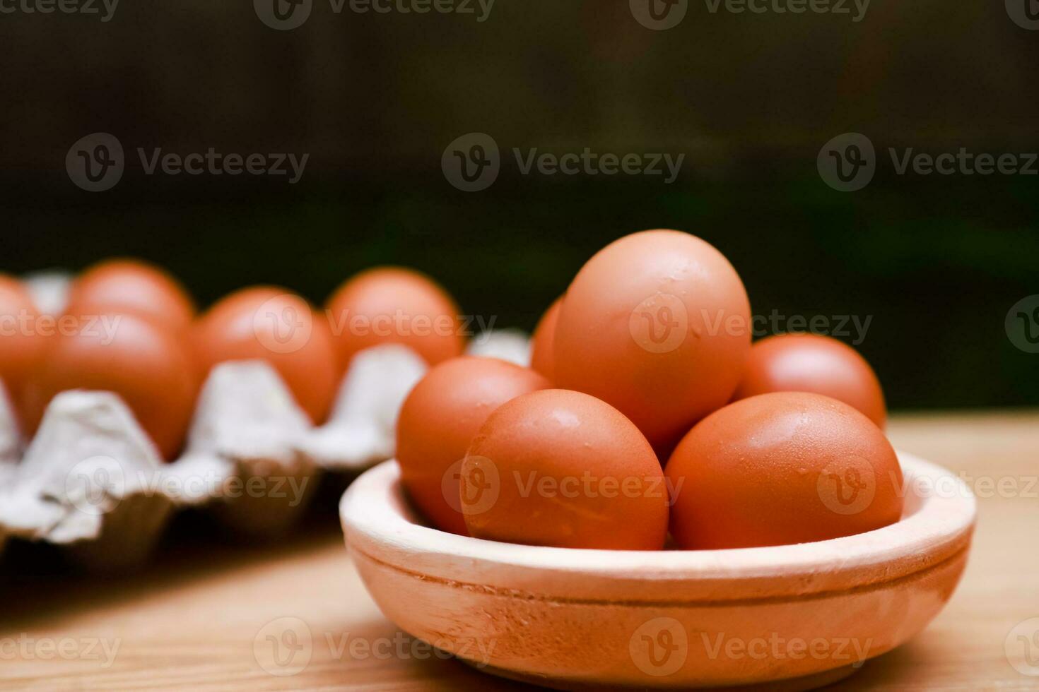 a few chicken eggs are placed in a wooden bowl photo