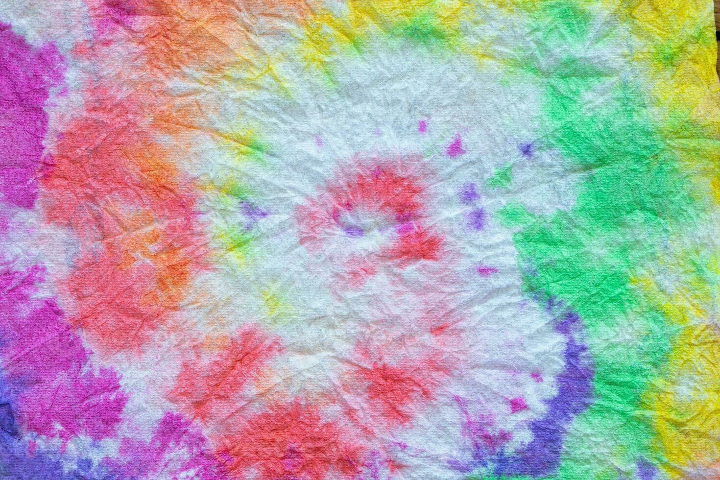 a colorful tie dye fabric on a wooden table photo