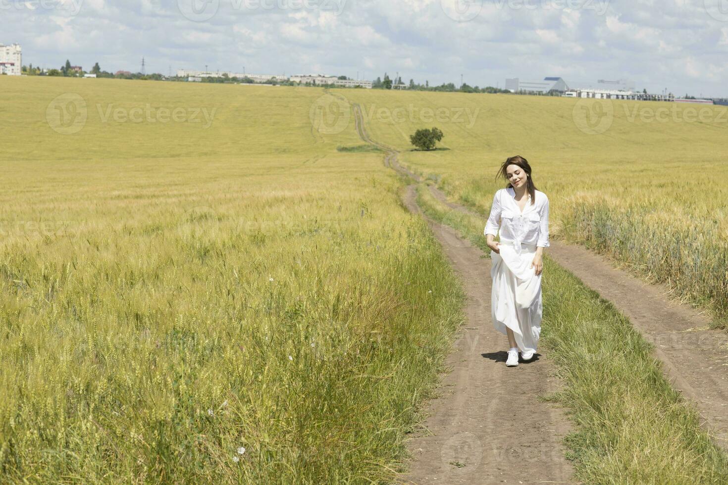 un mujer en un blanco vestir en pie en un campo foto