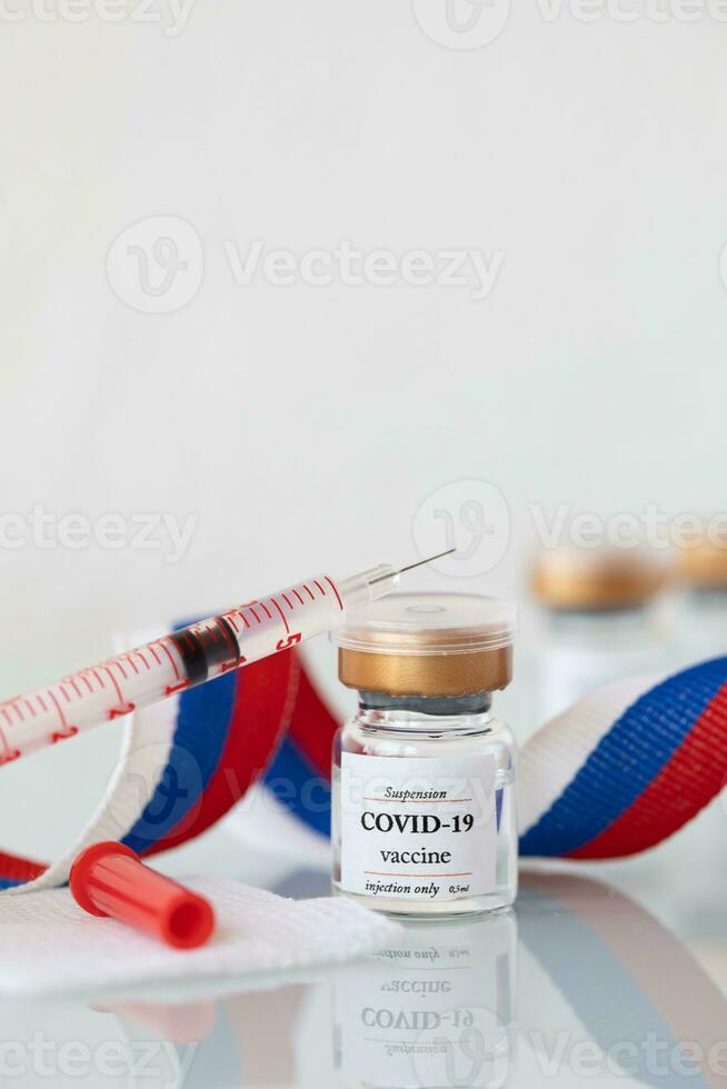 vaccine and syringe on a table with ribbon photo