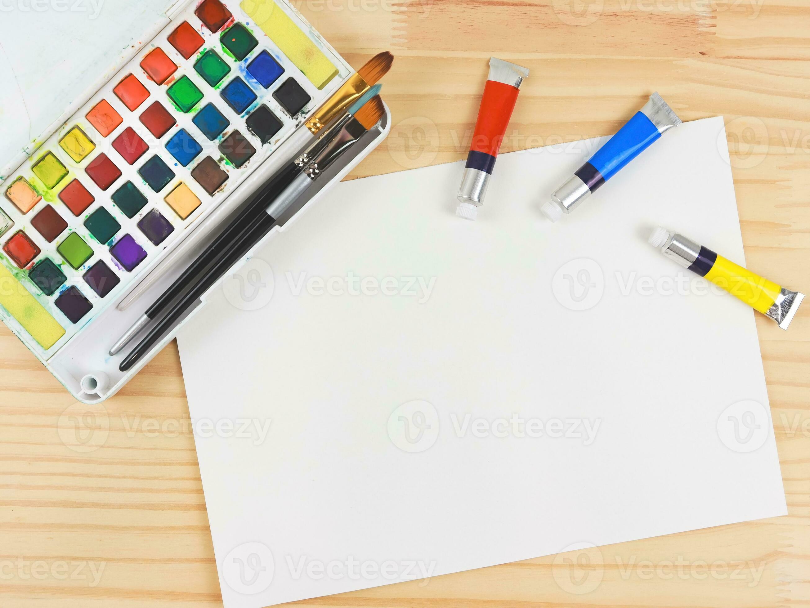 https://static.vecteezy.com/system/resources/previews/027/422/040/large_2x/flat-lay-of-artist-workspace-blank-paper-drawing-tools-stationary-supplies-watercolor-paints-and-brushes-and-paper-on-wooden-table-copy-space-photo.jpg