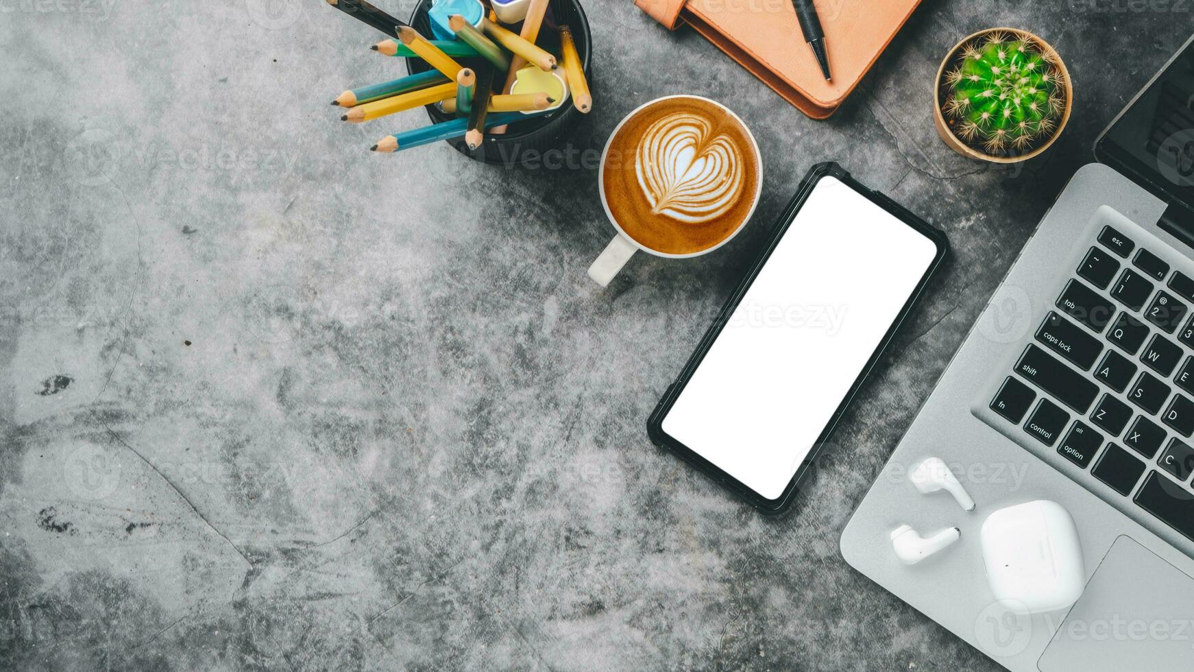 parte superior vista, oscuro oficina escritorio con ordenador portátil computadora, blanco pantalla inteligente teléfono, taza de café, bolígrafo, auricular y computadora portátil, Copiar espacio, burlarse de arriba. foto