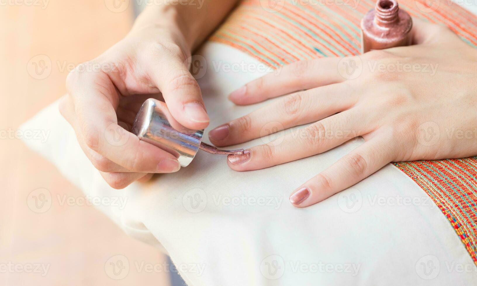 Woman getting nail manicure paint on hands. photo